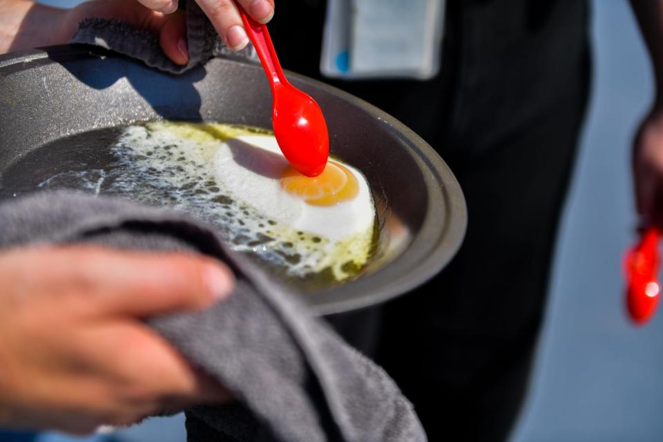 The Tennessean employees cook an egg outside as temperatures reached triple digits in Nashville