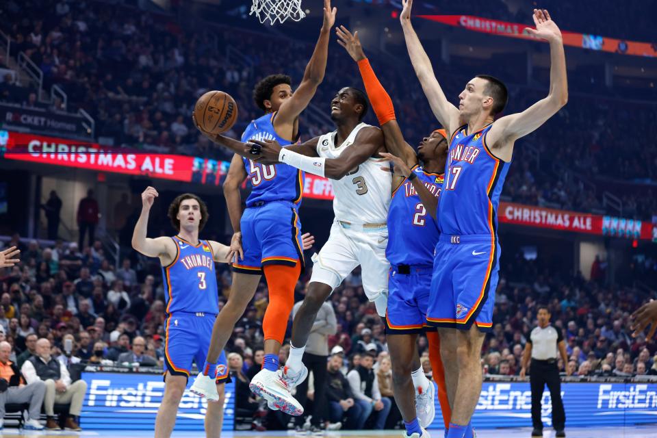 Cleveland Cavaliers guard Caris LeVert (3) shoots against Oklahoma City Thunder forward Jeremiah Robinson-Earl (50), guard Shai Gilgeous-Alexander (2) and forward Aleksej Pokusevski (17) during the first half of an NBA basketball game, Saturday, Dec. 10, 2022, in Cleveland. (AP Photo/Ron Schwane)