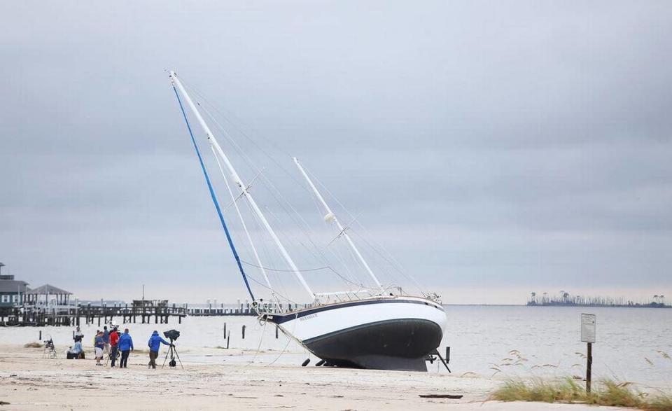 Television crews surround a boat that washed ashore on the beach in Biloxi sometime during the night as Hurricane Nate made landfall. Amanda McCoy/amccoy@sunherald.com