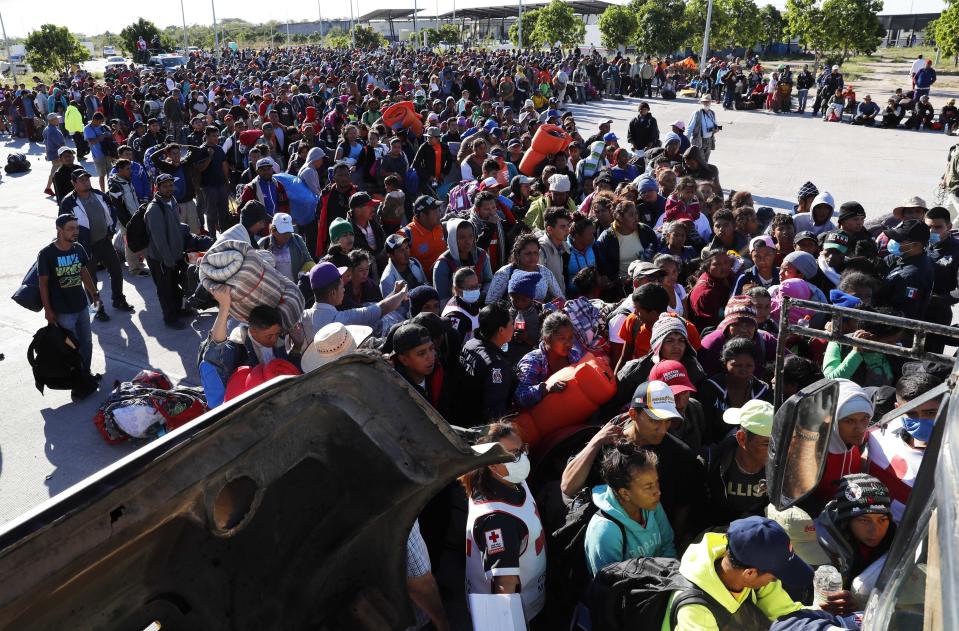 Migrants traveling with a caravan hoping to reach the U.S. border, wait in line to board buses in La Concha, Mexico, Wednesday, Nov. 14, 2018. Buses and trucks are carrying some migrants into the state of Sinaloa along the Gulf of California and further northward into the border state of Sonora. The bulk of the main caravan appeared to be about 1,100 miles from the border, but was moving hundreds of miles per day. (AP Photo/Marco Ugarte)