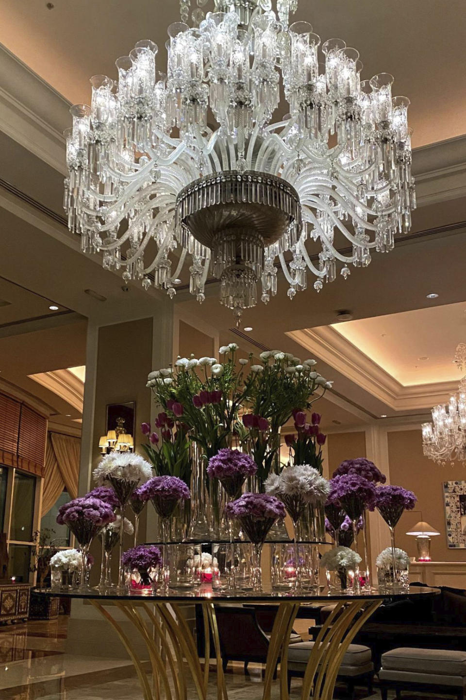 This photo provided to The Associated Press shows a chandelier and fresh flowers in the lobby of the Four Seasons Damascus hotel in February 2021. World Health Organization Syria leader Dr. Akjemal Magtymova organized a party here in May 2021, when she received a leadership award from Tufts University, her alma mater. Held at this exclusive hotel in Damascus, the party included a guest list of about 50, at a time when fewer than 1% of the Syrian population had received a single dose of COVID-19 vaccine. (AP Photo)