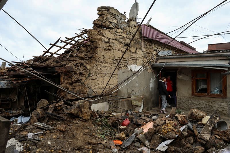 Mujeres de pie junto a su casa gravemente dañada por un ataque con drones rusos, en medio del ataque de Rusia a Ucrania, en Odesa