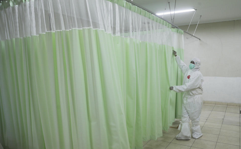 A medics inspects makeshift isolation rooms at Patriot Candrabhaga stadium prepared to become a quarantine facility for people showing symptoms of the COVID-19 amid the new coronavirus outbreak in Bekasi on the outskirts of Jakarta, Indonesia, Wednesday, Sept. 9, 2020. While Indonesia has recorded more deaths from the coronavirus than any other Southeast Asian country, it also has seen by far the most fatalities among medical workers in the region, leading to concerns about the long-term impact on the nation's fragile healthcare system. (AP Photo/Achmad Ibrahim)