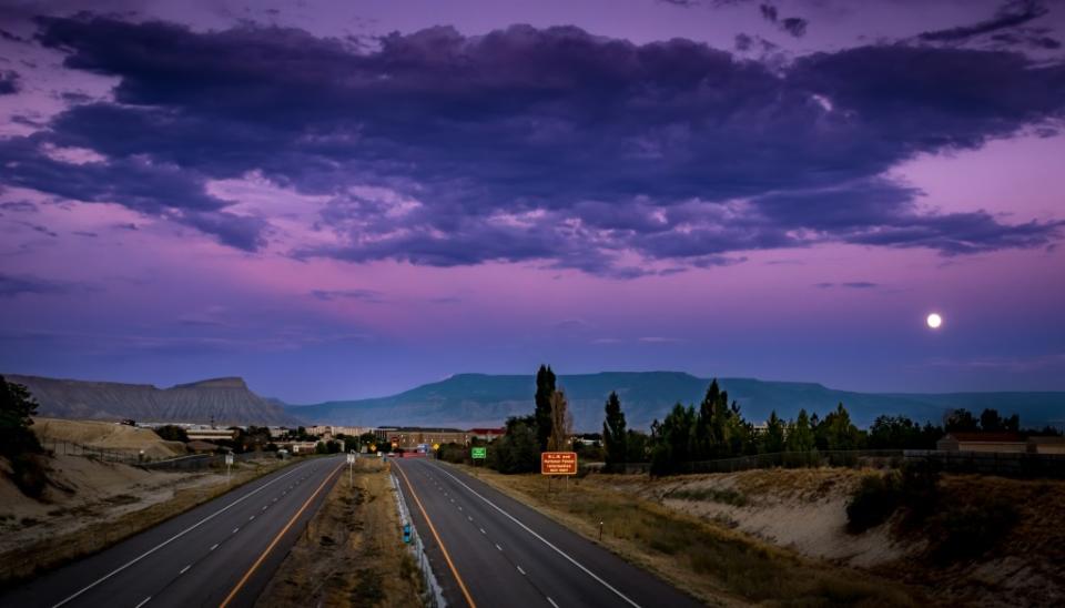 Beautiful sunset picture of Interstate I70, Grand Junction, Colorado, with Grand Mesa in the background via Getty Images