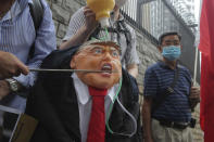 Pro-China supporters hit the effigy of U.S. President Donald Trump outside the U.S. Consulate during a protest in Hong Kong, Saturday, May 30, 2020. President Donald Trump has announced a series of measures aimed at China as a rift between the two countries grows. He said Friday that he would withdraw funding from the World Health Organization, end Hong Kong's special trade status and suspend visas of Chinese graduate students suspected of conducting research on behalf of their government. (AP Photo/Kin Cheung)