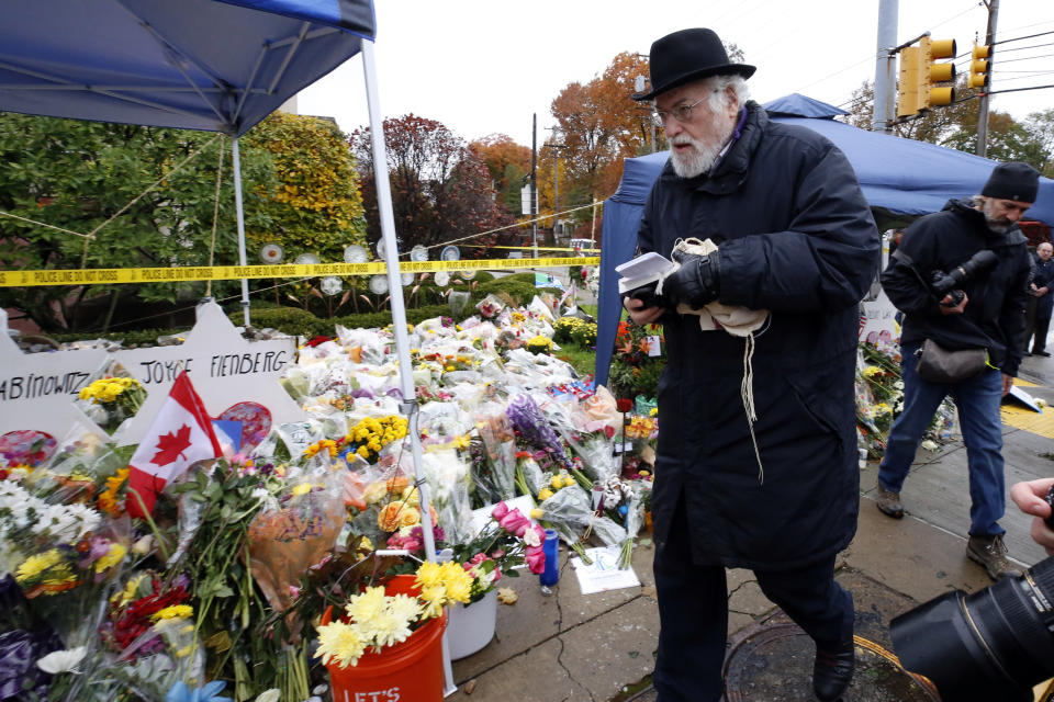 FILE - In this Saturday, Nov. 3, 2018 file photo, Rabbi Chuck Diamond, center, arrives on the street corner outside the Tree of Life Synagogue in the Squirrel Hill neighborhood of Pittsburgh to lead a Shabbat morning service, a week after 11 people were killed and six wound when their worship was interrupted by a gunman's bullets. Community service projects, an overseas concert and a virtual remembrance are among multiple ways the deadliest attack on Jews in U.S. history will be commemorated. Sunday marks the one-year anniversary of the shooting at the Tree of Life synagogue in Pittsburgh that killed 11 worshippers and injured seven. (AP Photo/Gene J. Puskar, File)