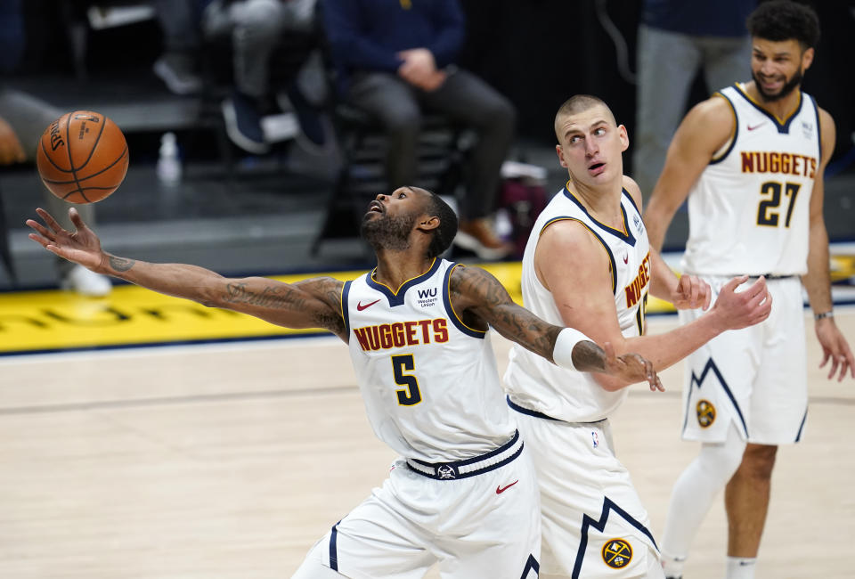 Denver Nuggets forward Will Barton, left, reaches out to pull in a rebound as center Nikola Jokic and guard Jamal Murray, right, look on in the second half of an NBA basketball game against the Oklahoma City Thunder Tuesday, Jan. 19, 2021, in Denver. (AP Photo/David Zalubowski)