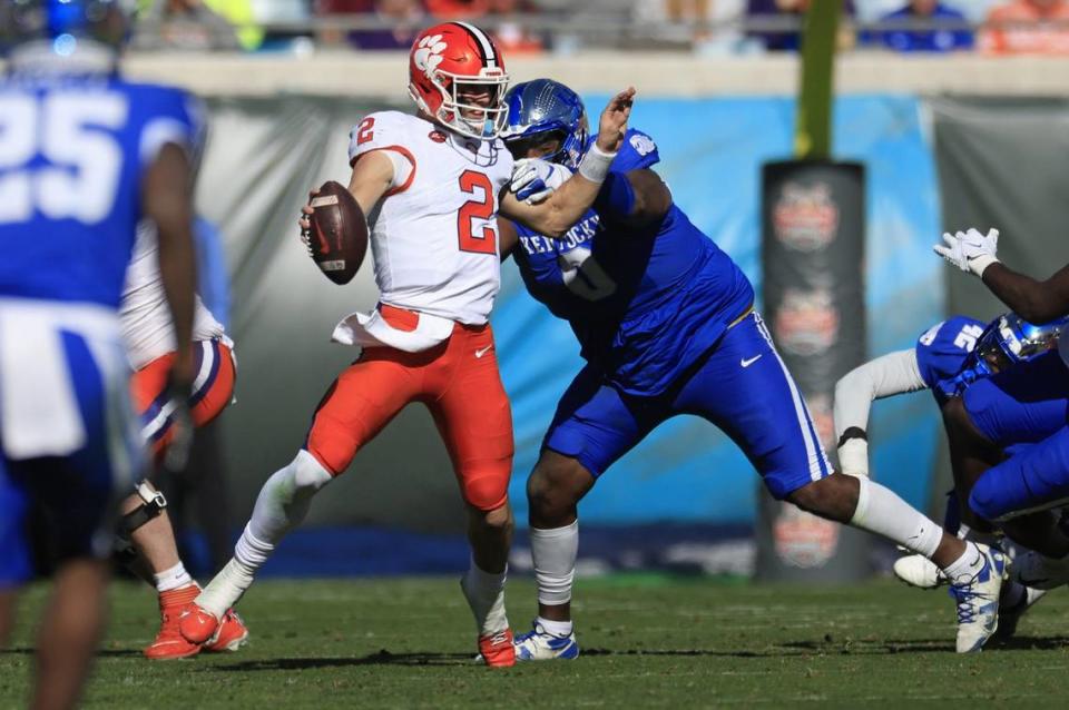 Kentucky defensive lineman Deone Walker, right, sacks Clemson quarterback Cade Klubnik (2) during the second quarter of the TaxSlayer Gator Bowl on Friday,