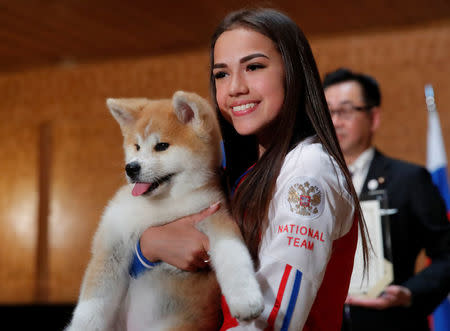 Russian figure skating gold medallist Alina Zagitova poses with an Akita Inu puppy presented to her in Moscow, Russia May 26, 2018. REUTERS/Maxim Shemetov