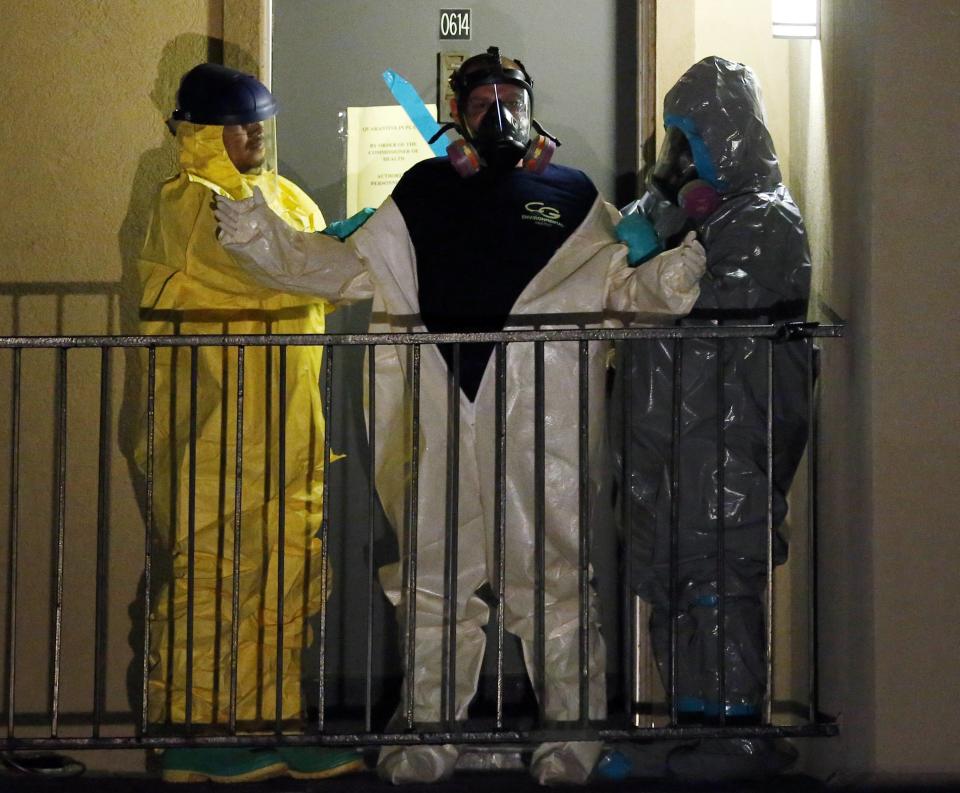 A worker in a hazardous material suit is helped to undress after coming out of an apartment unit where a man diagnosed with the Ebola virus was staying in Dallas, Texas, October 5, 2014. (REUTERS/Jim Young)