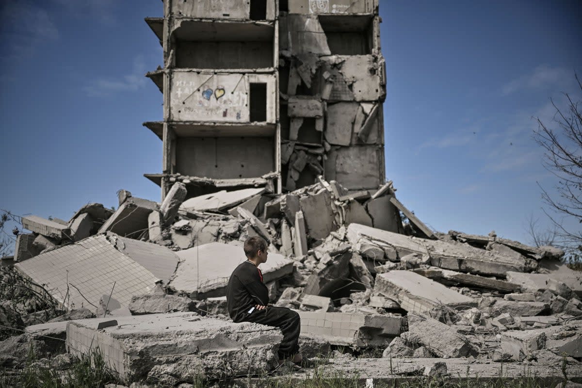 A young boy sits in front of a damaged building after a strike in Kramatorsk in the eastern Ukranian region of Donbas (AFP via Getty Images)