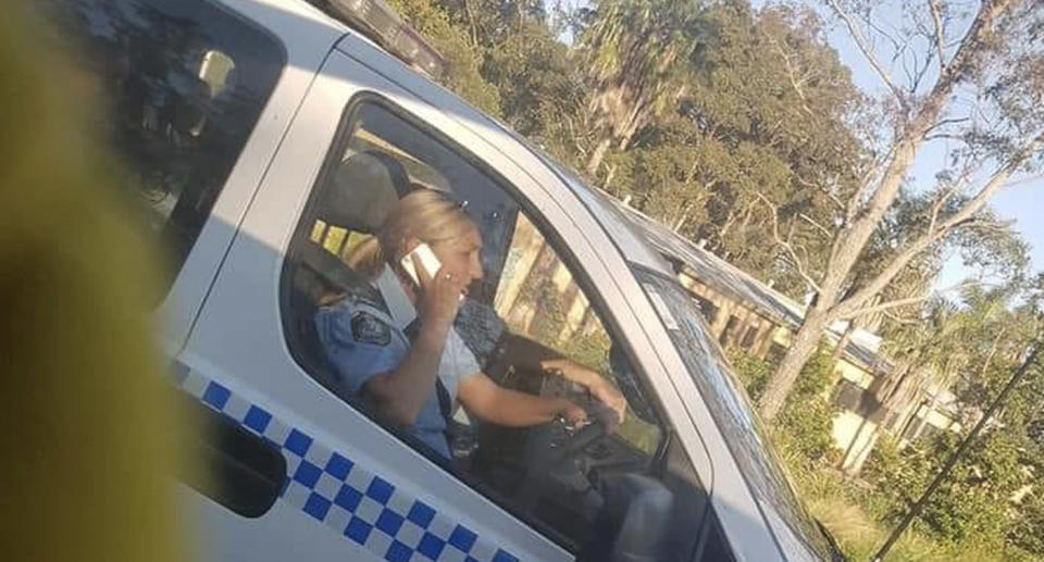 A police woman seen talking on her mobile phone behind the wheel. 