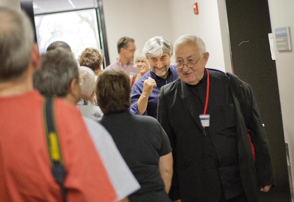 In this Friday, Sept. 20, 2013 photo, airport chaplains Michael Selinotakis, second from right, and Antonin Blanchi, right, both of Nice Cote d'Azur Airport in France, greet fellow chaplains attending the International Association of Civil Aviation Chaplains' annual conference at Delta Air Lines' headquarters, in Atlanta. Airports are mini-cities with their own movie theaters, fire departments and shopping malls. Many also have chapels, which are staffed by a mix of 350 part- and full-time chaplains worldwide who are Catholic, Protestant and, to a lesser extent, Jewish, Muslim or Sikh. (AP Photo/David Goldman)