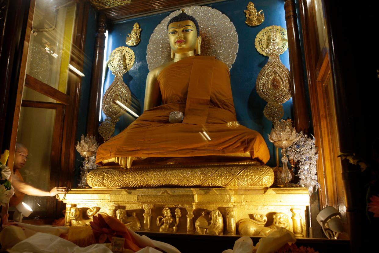 A priest makes an offering at a statue of Buddha in the Mahabodhi temple at Bodh Gaya, India, on Wednesday, Jan. 6, 2010. Bodh Gaya is the town where Prince Siddhartha Gautama attained enlightenment after intense meditation and became the Buddha, about 2,600 years ago.