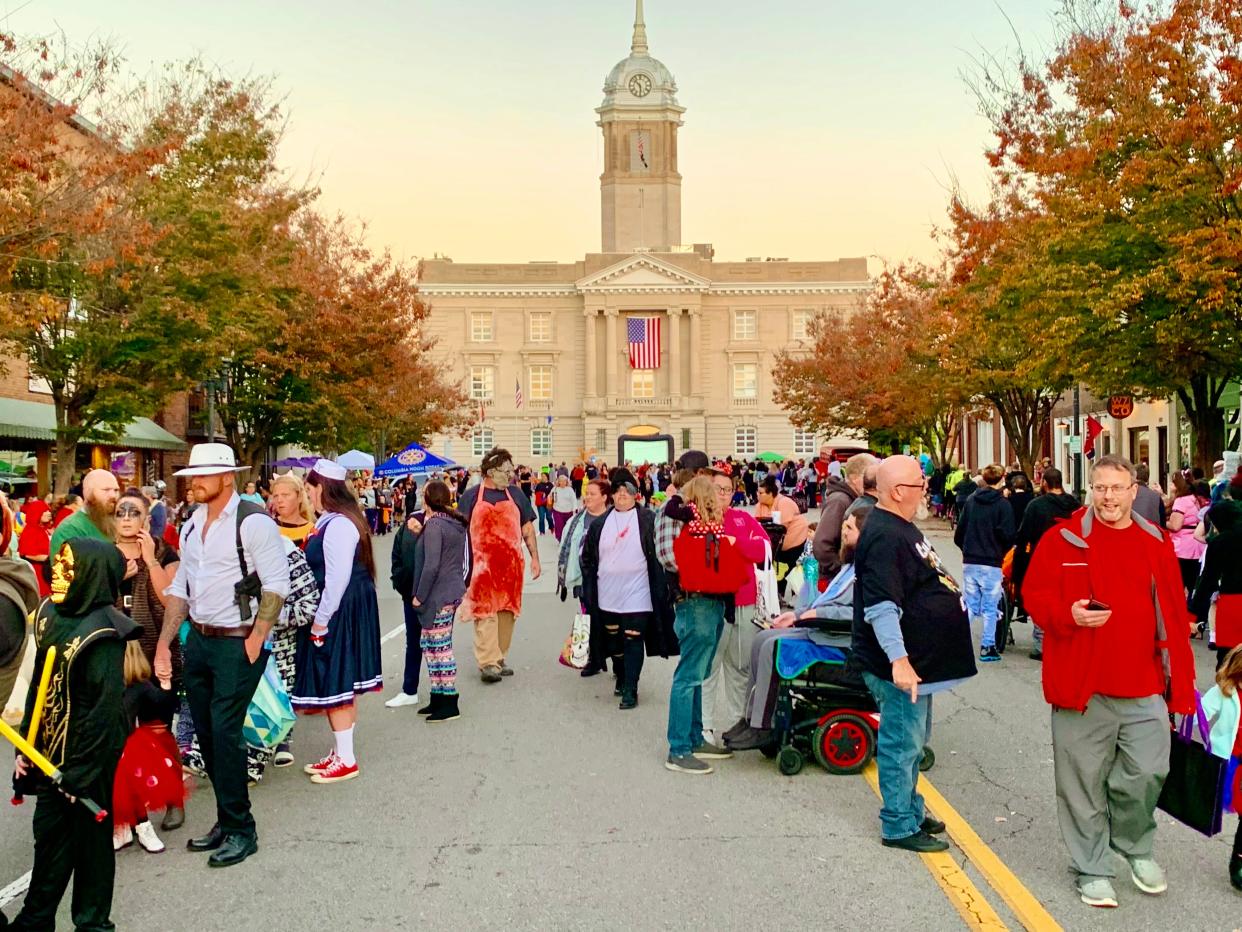 Hundreds of costumed citizens line up for candy and haunts at the 2021 Haunting in the District in downtown Columbia.