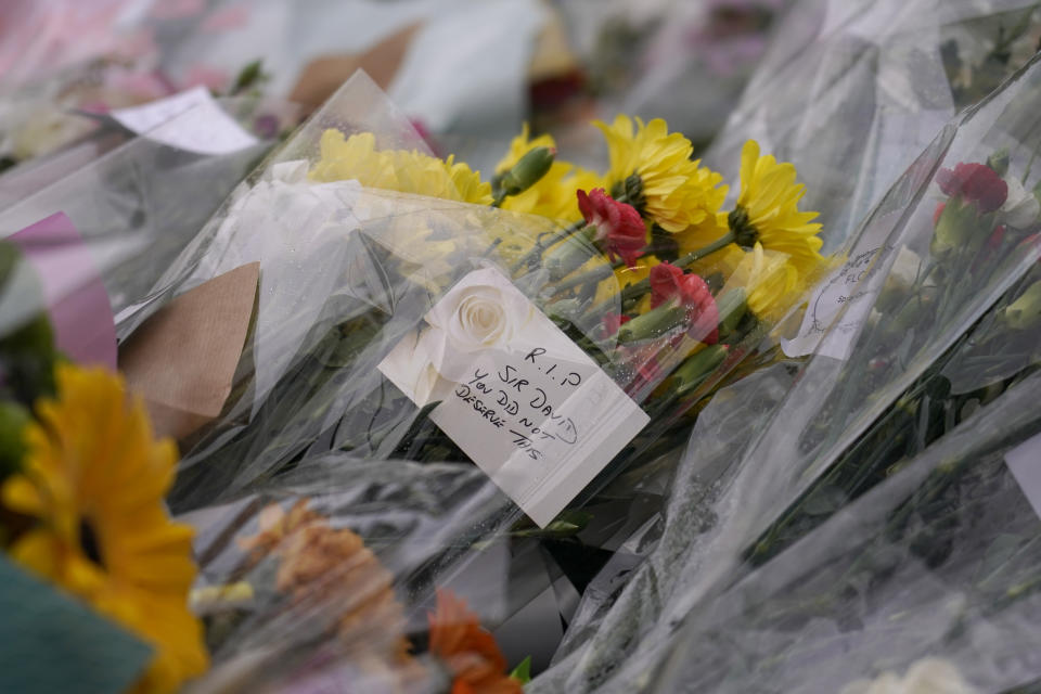 A note is seen by floral tributes near the site where a member of Parliament was killed on Friday, in Leigh-on-Sea, Essex, England, Saturday, Oct. 16, 2021. David Amess, a long-serving member of Parliament was stabbed to death during a meeting with constituents at a church in Leigh-on-Sea on Friday, in what police said was a terrorist incident. A 25-year-old British man is in custody. (AP Photo/Alberto Pezzali)