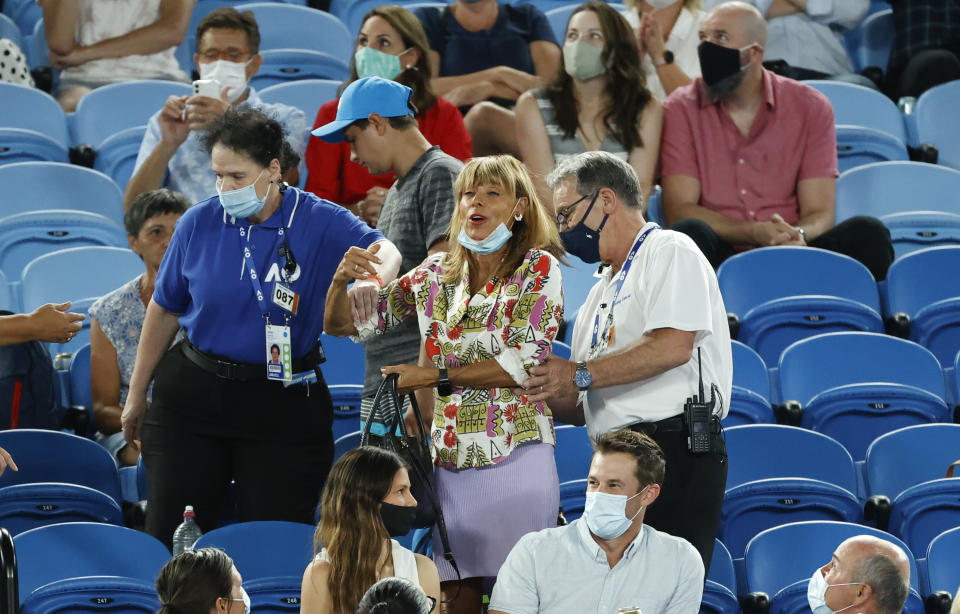 A spectator is escorted from Rod Laver Arena by security during the second round match between Spain's Rafael Nadal and United States' Michael Mmoh at the Australian Open tennis championship in Melbourne, Australia, Thursday, Feb. 11, 2021.(AP Photo/Rick Rycroft)