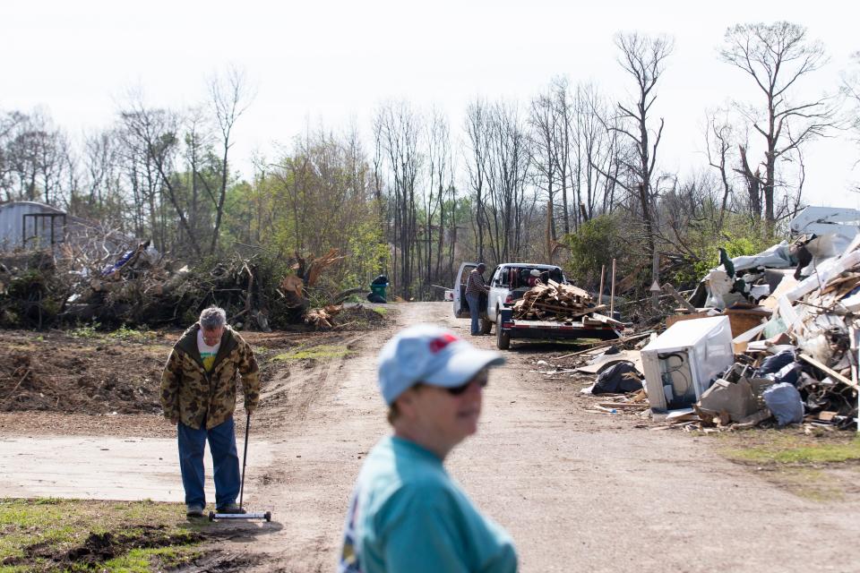 Hallie Gail Crook looks at the piles of debris on the road next to her and her brother’s home in Silver City on Tuesday. An EF-4 tornado damaged parts of Silver City and killed at least two residents on Friday night.