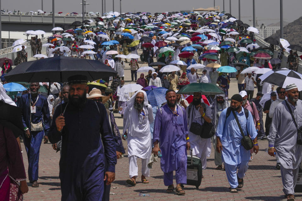 Muslim pilgrims use umbrellas to shield themselves from the sun as they arrive to cast stones at pillars in the symbolic stoning of the devil, the last rite of the annual hajj, in Mina, near the holy city of Mecca, Saudi Arabia, Tuesday, June 18, 2024. Muslim pilgrims were wrapping up the Hajj pilgrimage in the deadly summer heat on Tuesday with the third day of the symbolic stoning of the devil, and the farewell circling around Kaaba in Mecca's Grand Mosque. (AP Photo/Rafiq Maqbool)