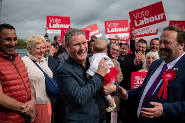 Labour party leader Sir Keir Starmer holds 5 month old baby as he speaks to supporters alongside newly elected Labour Councillor Vince Maple, Chatham Central.