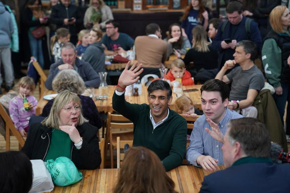 Britain's Prime Minister Rishi Sunak, centre, meets members of the public during a visit to Altrincham Market in Greater Manchester, England, Friday Jan. 5, 2024. (Jacob King/Pool via AP)