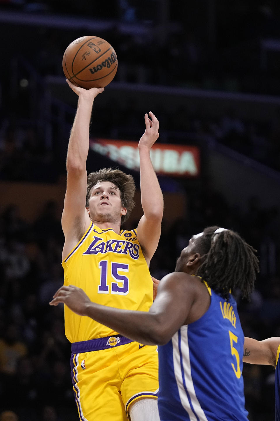 Los Angeles Lakers guard Austin Reaves, left, shoots as Golden State Warriors forward Kevon Looney defends during the first half of an NBA preseason basketball game Friday, Oct. 13, 2023, in Los Angeles. (AP Photo/Mark J. Terrill)