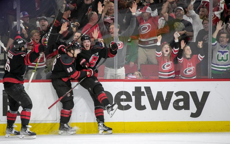 Carolina Hurricanes’ Andrei Svechnikov (37) celebrates with teammates Vincent Trocheck (16) and Martin Necas (88) after scoring to secure a 3-1 victory over the New York Rangers on Thursday, May 26, 2022 during game five of the Stanley Cup second round at PNC Arena in Raleigh, N.C.