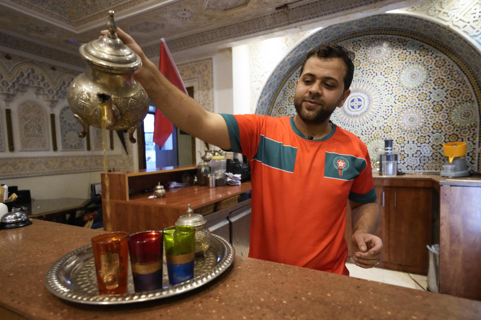 Moroccan waiter Yassin al-Youssfi serves Moroccan tea inside the Marrakech restaurant, in Doha, Qatar on Sunday Dec. 4, 2022. (AP Photo/Ashley Landis)