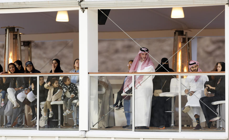 In this Saturday, Dec. 14, 2019 photo, Equestrian fans watch the Diriyah Equestrian Festival, where male and female equestrians are riding side-by-side for the first time in Riyadh Saudi Arabia. Prince Abdulaziz bin Turki al-Faisal, who leads the General Sports Authority, said during an interview with the Associated Press that "Sports has been a tool for social change within the kingdom," , adding a lot of that effort has been geared toward encouraging and open the realm of sports to Saudi women. (AP Photo/Amr Nabil)