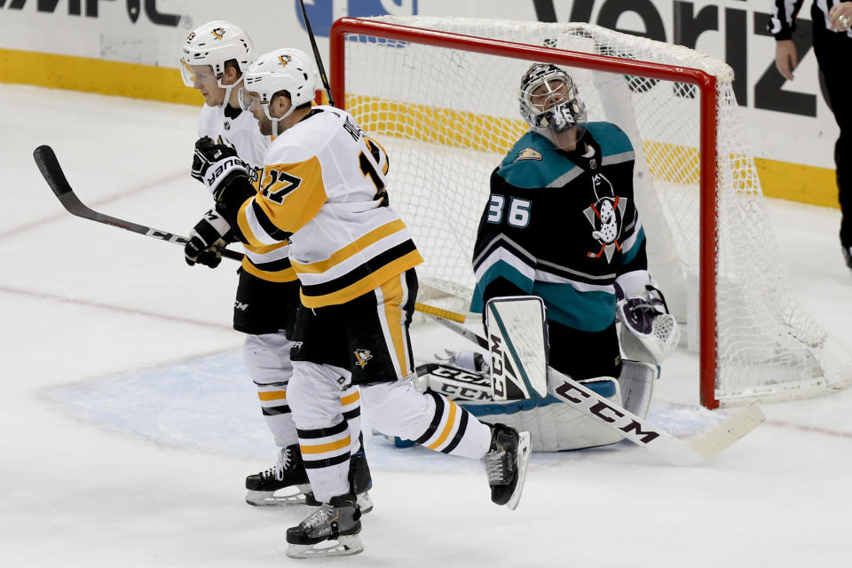 Anaheim Ducks goaltender John Gibson (36) looks up after Pittsburgh Penguins' Bryan Rust (17) scored during the first period of an NHL hockey game, Monday, Dec. 17, 2018, in Pittsburgh. Rust skates away with Jake Guentzel. (AP Photo/Keith Srakocic)