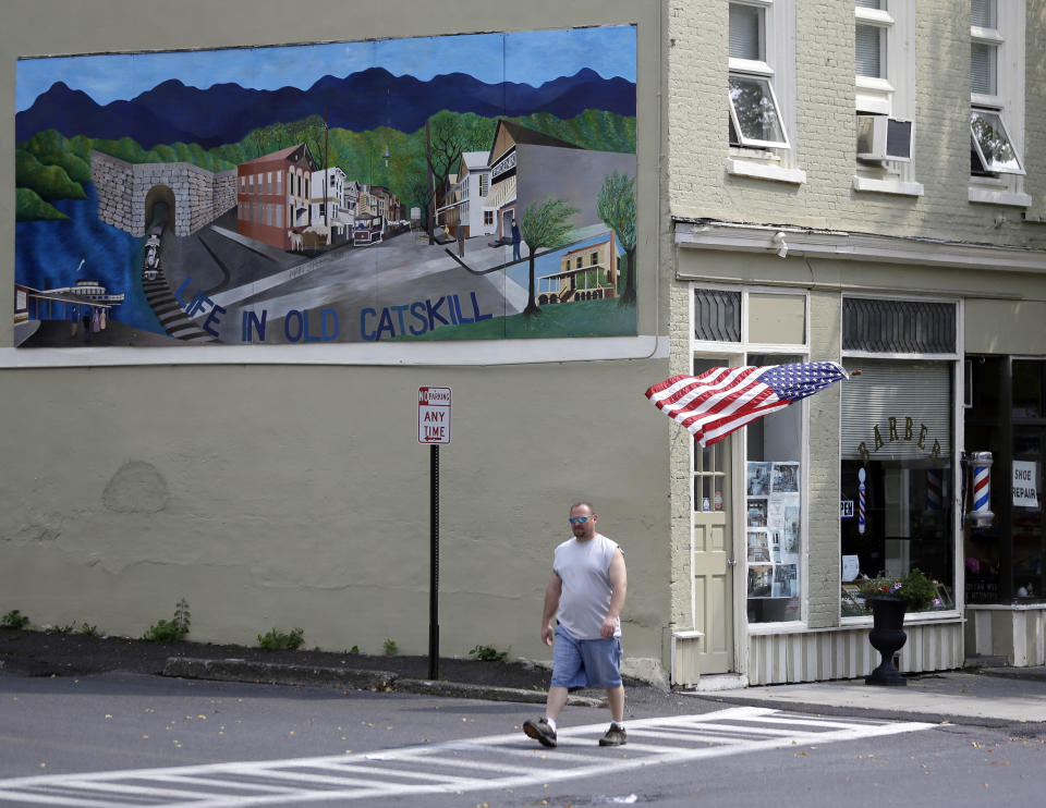 A pedestrian walks along Main Street on Thursday, Sept. 12, 2013, in Catskill, N.Y. A group of locals in this Hudson River village are offering the right chef space on Main Street free rent for a year. The hope is the right restaurant will give the growing number of arrivals downriver from New York City an attractive place to eat. (AP Photo/Mike Groll)