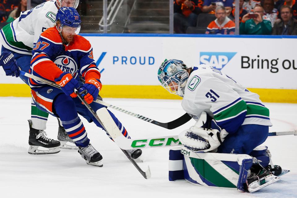 The Edmonton Oilers' Warren Foegele looks for a loose puck in front of Vancouver Canucks goaltender Arturs Silovs.