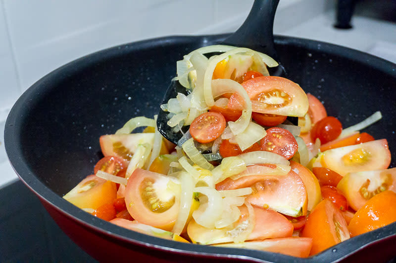 Mixing tomatoes and onions for Lemony Braised Chicken Legs