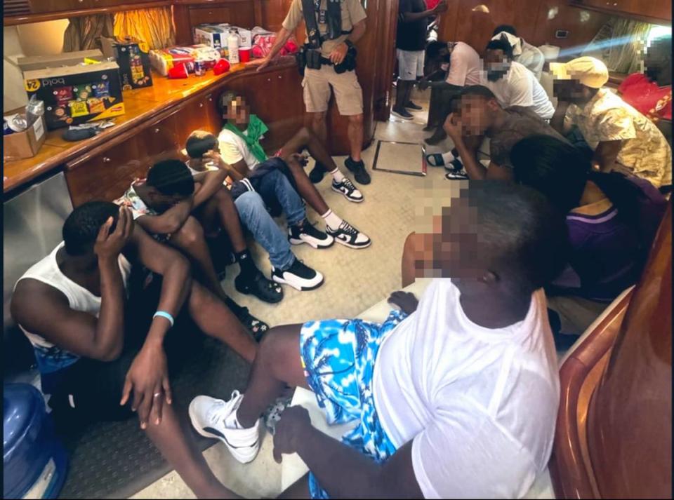 A group of people from Haiti sit below the deck of a 60-foot yacht that was stopped by local police and federal agents near Key Biscayne Friday, April 19, 2024.