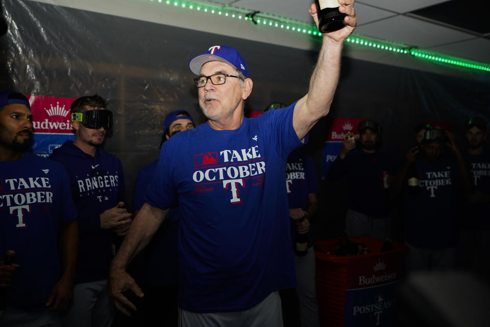Texas Rangers manager Bruce Bochy speaks to his team in the clubhouse as they celebrate clinching a playoff spot in the American League after a 6-1 win over the Seattle Mariners in a baseball game, Saturday, Sept. 30, 2023, in Seattle. (AP Photo/Lindsey Wasson)