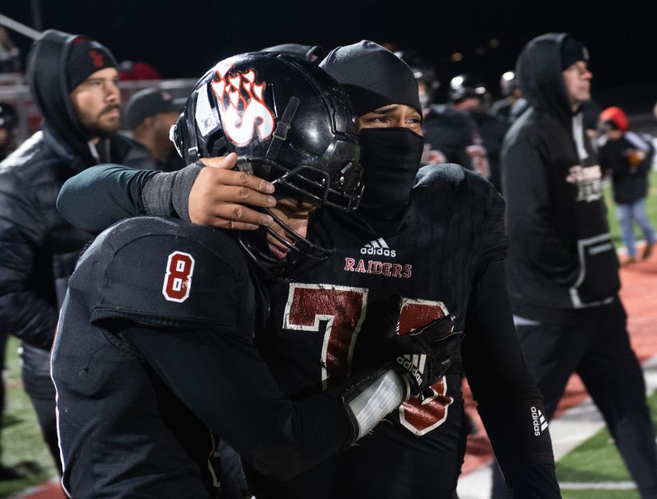 Southridge’s Eric Vanegas (76) and Yamil Arroyo (8) console each other after the Southridge Raiders lose against the Lawrenceburg Tigers for the Class 3A Regional at Southridge High School in Huntingburg, Ind.,  Saturday evening, Nov. 12, 2022.