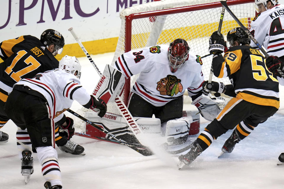 Chicago Blackhawks goaltender Petr Mrazek stops a shot by Pittsburgh Penguins' Jake Guentzel (59) during the first period of an NHL hockey game in Pittsburgh, Tuesday, April 11, 2023. (AP Photo/Gene J. Puskar)