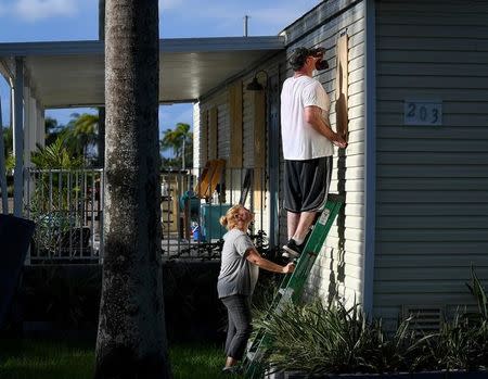 FILE PHOTO: Yana and Jeremy Cauble board up their mobile home in preparation for Hurricane Irma in Homestead, Florida, U.S., September 7, 2017. REUTERS/Bryan Woolston/File Photo