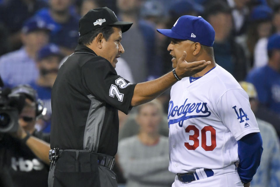 Los Angeles Dodgers manager Dave Roberts talks with home plate umpire Alfonso Marquez after the second inning in Game 5 of the baseball team's National League Division Series against the Washington Nationals on Wednesday, Oct. 9, 2019, in Los Angeles. (AP Photo/Mark J. Terrill)