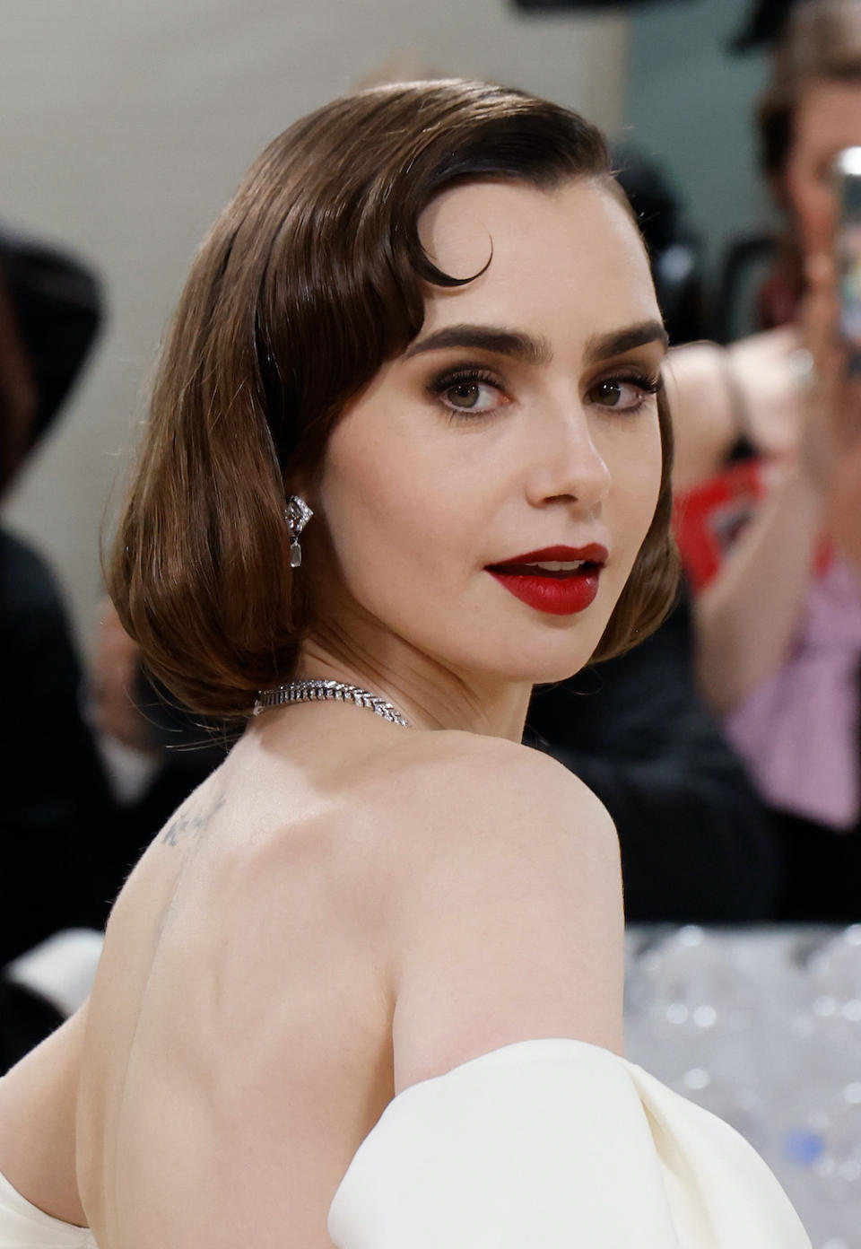 Lily Collins's brown smokey eye and red lip