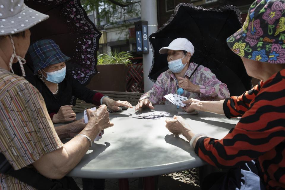 Women play cards in a public park near a remembrance ceremony for Vincent Chin in Chinatown, Sunday, June 23, 2024, in Boston. Over the weekend, vigils were held across the country to honor the memory of Chin, who was killed by two white men in 1982 in Detroit. (AP Photo/Michael Dwyer)