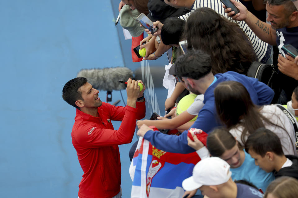 Serbia's Novak Djokovic signs autographs after defeating France's Quentin Halys during their Round of 16 match at the Adelaide International Tennis tournament in Adelaide, Australia, Thursday, Jan. 5, 2023. (AP Photo/Kelly Barnes)