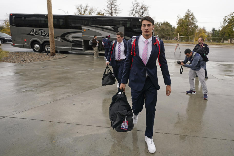 Arizona football players arrive at Rice-Eccles Stadium before their NCAA college football game against Utah Saturday, Nov. 5, 2022, in Salt Lake City. Travel and food are the primary areas with increased costs. Schools in major conferences are working with boosters and other partners to try to bridge the financial gap. (AP Photo/Rick Bowmer)