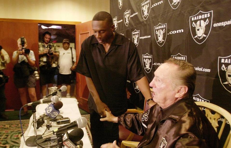 Football star Tim Brown shakes hands with Oakland Raiders’ owner Al Davis after announcing his departure from the football team during a press conference in Napa , California, on Wednesday, August 4, 2004.