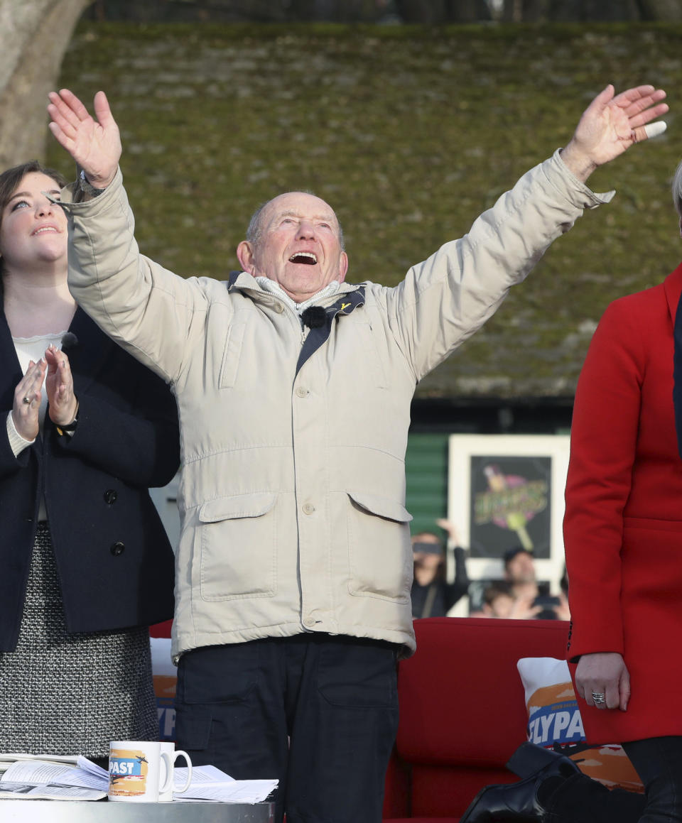 Tony Foulds, 82, waves from Endcliffe Park in Sheffield, as warplanes from Britain and the United States stage a joint flypast tribute to ten US airmen Friday Feb. 22, 2019, 75-years after Foulds witnessed the crash that killed them. Foulds was just a child playing in the park on Feb. 22, 1944, when a U.S. Air Force crew decided to crash and die rather than take the chance of hitting the playing children. For decades Foulds has tended a memorial dedicated to honouring the 10 U.S. airmen who died in the plane crash at Endcliffe Park, and today the flypast fulfils his wish for the men who saved his life. (Danny Lawson/PA via AP)