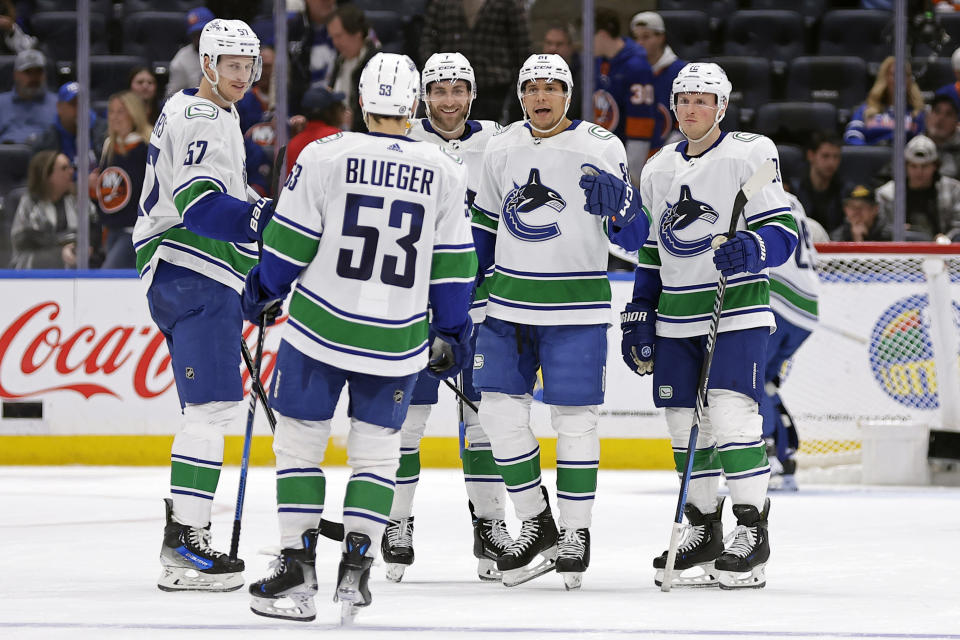 Vancouver Canucks center Dakota Joshua, second right, celebrates with teammates after scoring an empty-net goal against the New York Islanders in the third period of an NHL hockey game Tuesday, Jan. 9, 2024, in Elmont, N.Y. The Canucks won 5-2. (AP Photo/Adam Hunger)