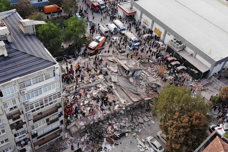 A picture from a drone shows people search for survivors at a collapsed building after a strong earthquake struck the Aegean Sea where some buildings collapsed in the coastal province of Izmir