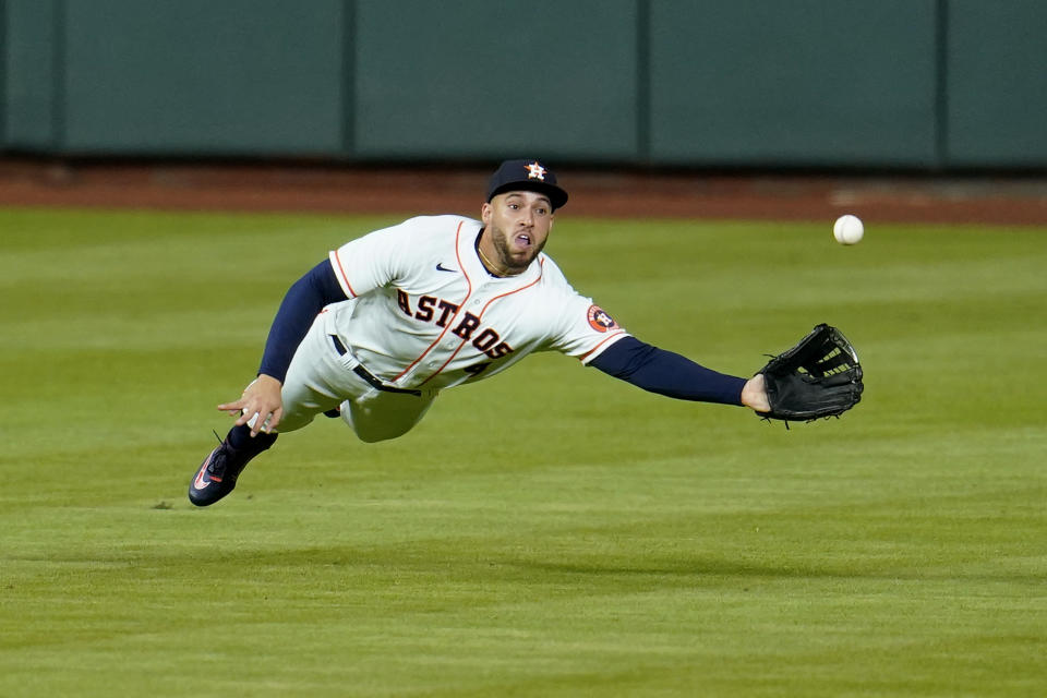 FILE - Inn this July 27, 2020, file photo, Houston Astros center fielder George Springer dives while trying to catch a double by Seattle Mariners' J.P. Crawford during the seventh inning of a baseball game in Houston. (AP Photo/David J. Phillip, File)