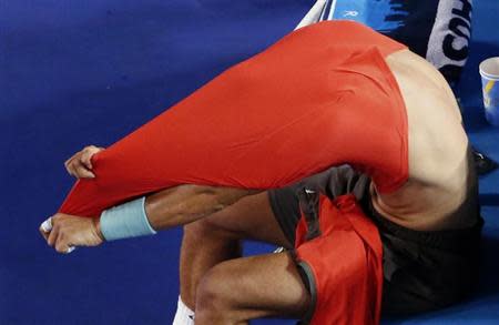 Rafael Nadal of Spain changes his shirt during his men's singles final match against Stanislas Wawrinka of Switzerland at the Australian Open 2014 tennis tournament in Melbourne January 26, 2014. REUTERS/David Gray