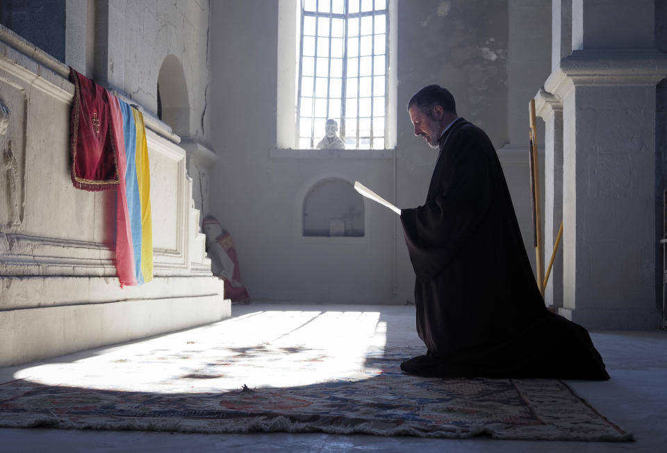 A priest prays in the Holy Savior Cathedral, damaged by shelling by Azerbaijan's artillery during a military conflict in Shushi, the separatist region of Nagorno-Karabakh, Saturday, Oct. 24, 2020. The heavy shelling forced residents of Stepanakert, the regional capital of Nagorno-Karabakh, into shelters, as emergency teams rushed to extinguish fires. Nagorno-Karabakh authorities said other towns in the region were also targeted by Azerbaijani artillery fire. (AP Photo)